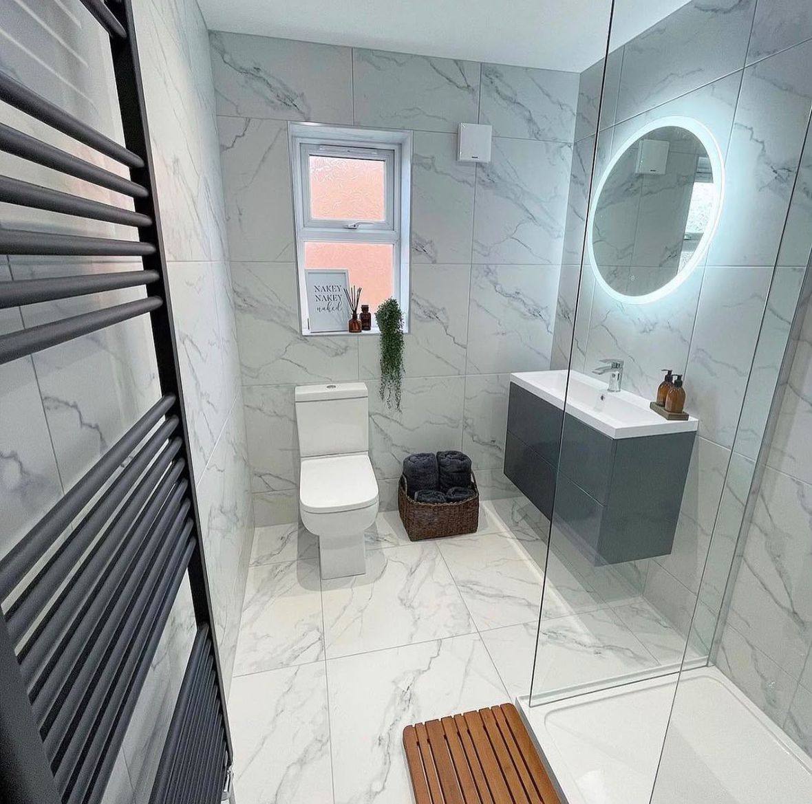 Completed bathroom renovation by INNA GROUP — frameless shower and stone tiling.