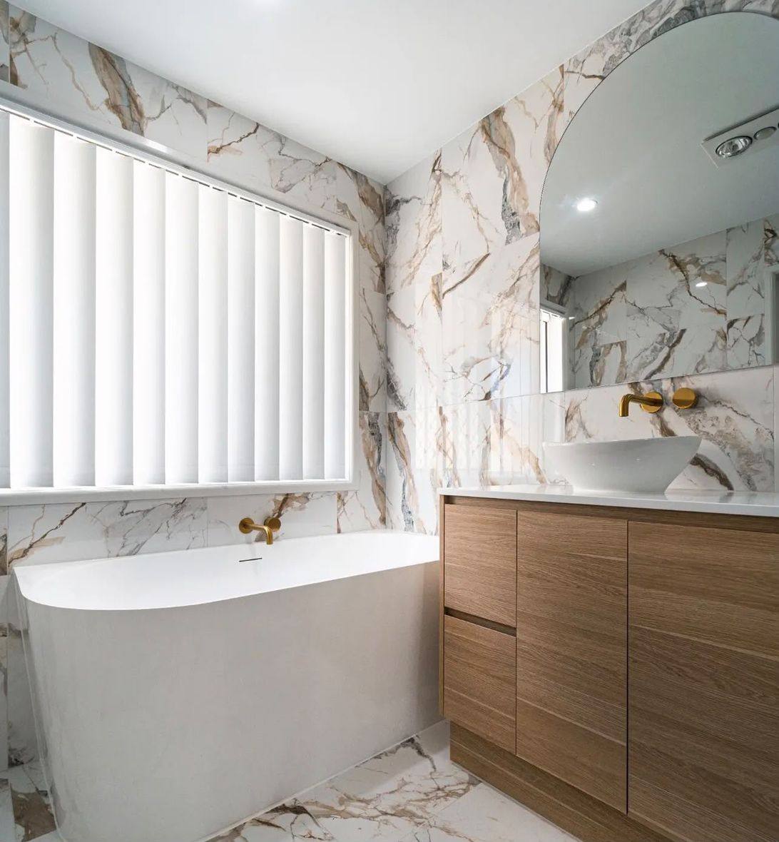 Completed bathroom renovation by INNA GROUP — frameless shower and stone tiling.